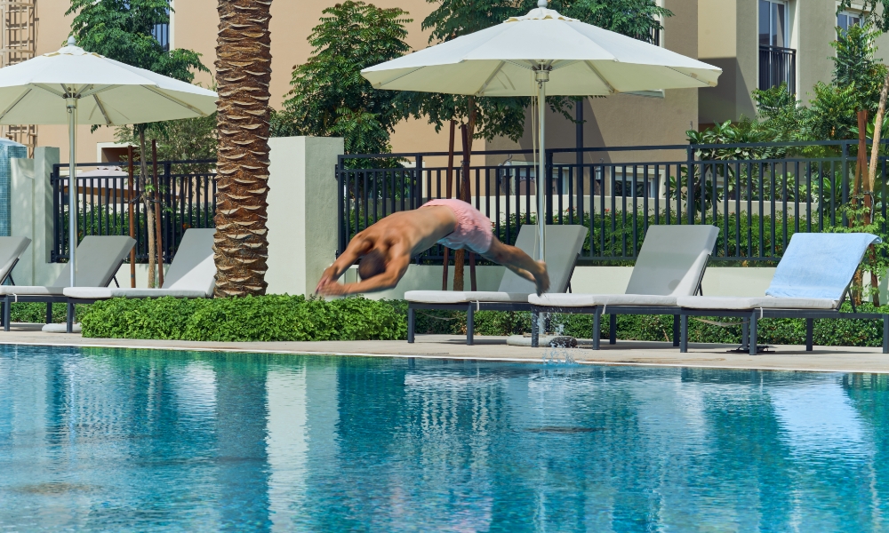 A Man Diving into a Swimming Pool at Villanova Amaranta Dubai